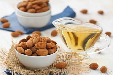 Almond nuts in a bowl and almond oil