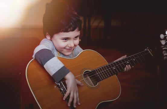 Child playing guitar. Learning concept.
