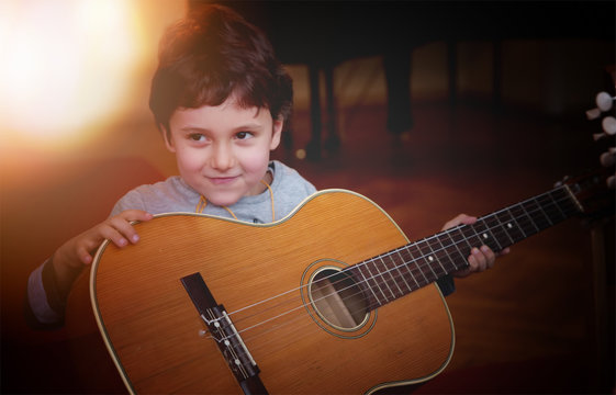Child playing guitar. Learning concept.
