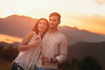 Portrait of young couple having good times in nature behind them is a beautiful sunset over Boka Bay