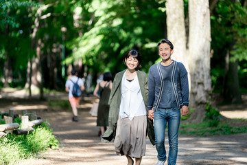 新緑の爽やかな小道を散歩するカップル（デート・夫婦）