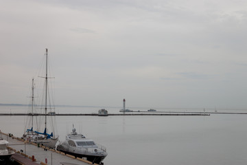 Fototapeta na wymiar lighthouse in the distance by the sea. seascape. port