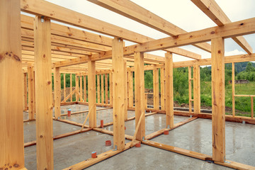 Wooden construction of an unfinished house. Skeleton of a building made of beams.