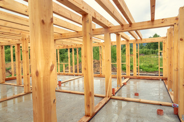Wooden construction of an unfinished house. Skeleton of a building made of beams.