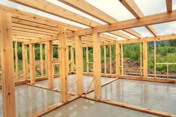 Wooden construction of an unfinished house. Skeleton of a building made of beams.