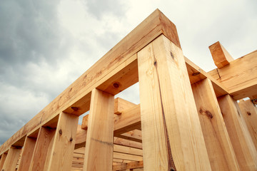 Wooden construction of an unfinished house. Skeleton of a building made of beams.