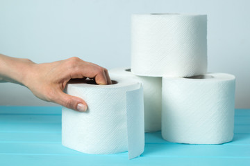The concept of diarrhea. The hand takes a roll of toilet paper.