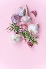 a composition of spices and herbs on a pink background, Himalayan salt with rosemary and garlic