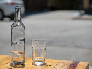 Bottle of water and glass served at an outdoor restaurant
