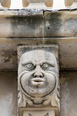 Fototapeta na wymiar Closeup view of mascarons with funny faces under the balcony of a baroque palace in the province of Syracuse, Sicily