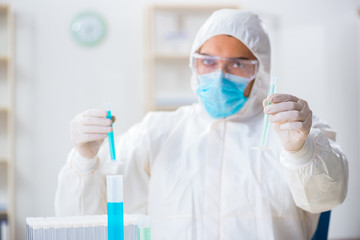 Young chemist student working in lab on chemicals