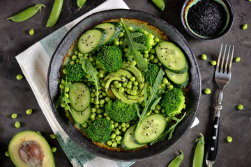 Healthy salad of broccoli, green peas, cucumber and avocado with arugula and olive oil. Healthy food. Top view