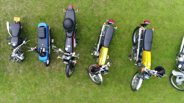 Aerial top down view slow and steady flight over classic mopeds are small motorcycles generally having less stringent licensing requirement than motorcycles colorful machines beautiful 4k quality