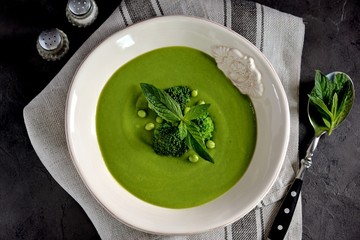 Healthy cream soup of fresh green peas with broccoli and mint