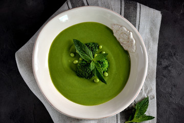 Healthy cream soup of fresh green peas with broccoli and mint