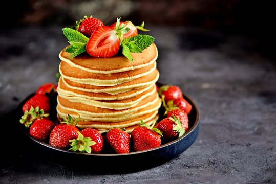 Delicious pancakes with fresh organic strawberries and mint