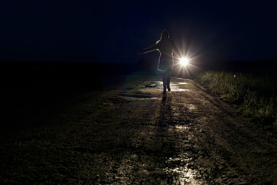 Running Scared Woman At Night In The Headlights Of A Car On A Country Road Silhouette