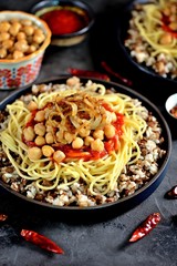 Kushari or Koushari - Egyptian dish of lentils, rice, pasta, chickpeas with tomato sauce and crispy onions. Arabic cuisine