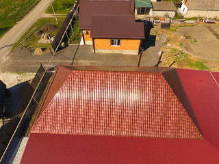 A house with a canopy over the courtyard. Roof from corrugated metal profile. Metal tiles