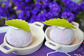 A colorful and delicious set of afternoon tea party in lavender theme: close up of Japanese daifukus with violet flowers background.