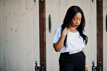 Stylish african american business woman with handbag on streets of city.