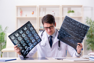 Young doctor looking at x-ray images in clinic