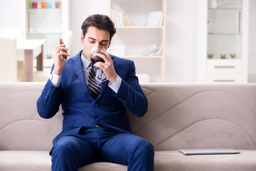 Businessman drinking wine sitting at home