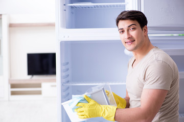 Man cleaning fridge in hygiene concept