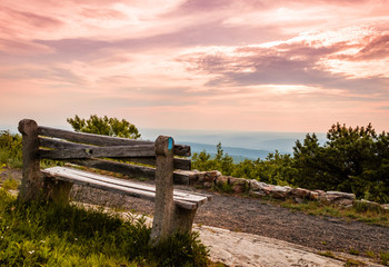 A lone bench faces the mountains under a stormy sunset at High Point State Park, the top of NJ
