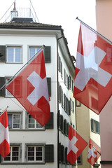 Old street in Zurich, decorated with swiss flags, Switzerland.