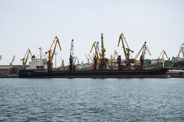 Cargo merchant ship, at the berth of the port terminal.