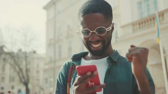 Handsome African American with glasses man using phone walking in city happy smile technology businessmen busy people attractive modern blac lifestyle smartphone ambitious mobile