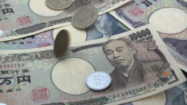 Close up of Japanese coin yen falling on banknotes 1000 and 10000 yen background. Super slow motion 120 fsp with sound.