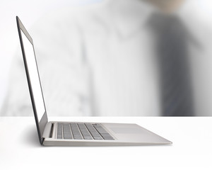 Silver laptop with blank monitor screen on white table