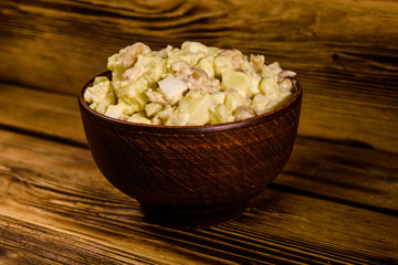 Salad with the haricot beans and meat dressed with mayonnaise in ceramic bowl