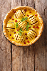 Freshly baked apple pie with cranberries, custard and mint closeup. Vertical top view from above