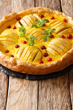 Delicious dessert food: apple cranberry pie with custard and mint close-up. vertical