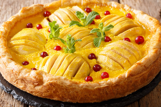 open apple pie with cranberries and custard is decorated with mint close-up. horizontal