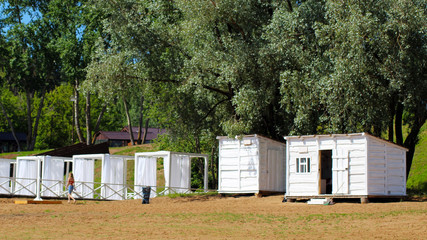 Beautiful small bathing houses on yellow sandy beach