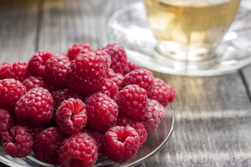 Raspberry and green tea from a linden on a wooden table