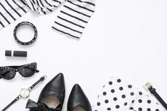 Set of black and white woman clothes and accessories on white background. Top view point, flat lay.
