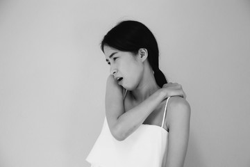 Fototapeta premium Young Asian woman having chronic neck and shoulder pain in black and white tone - Healthcare and Medical concept