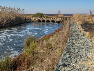 Old low water concrete bridge with a modern gabion retaining wall to control erosion image with copy space in landscape format