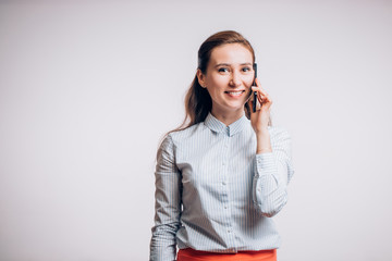 Beautiful business woman talks through a smartphone, smiling on the phone