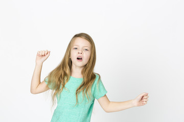 beautiful young girl is happy and dancing and posing in the studio in front of white background