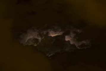 Lightning among the clouds in the night sky