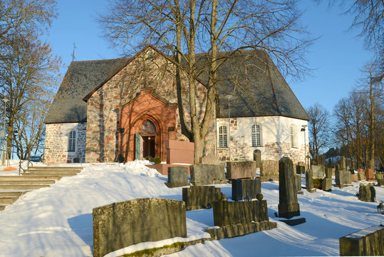 Medieval Lutheran Church in the old city cemetery Sunny February day. Halikko, Finland
