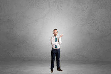 Alone handsome businessman standing in a dark empty room