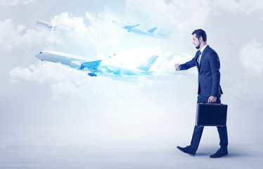 Elegant businessman going somewhere with briefcase and airplane on the background
