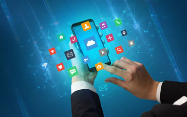 Female hand using smartphone with colorful application icons around